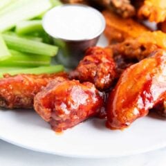 Crispy baked chicken wings on a plate with celery and ranch.