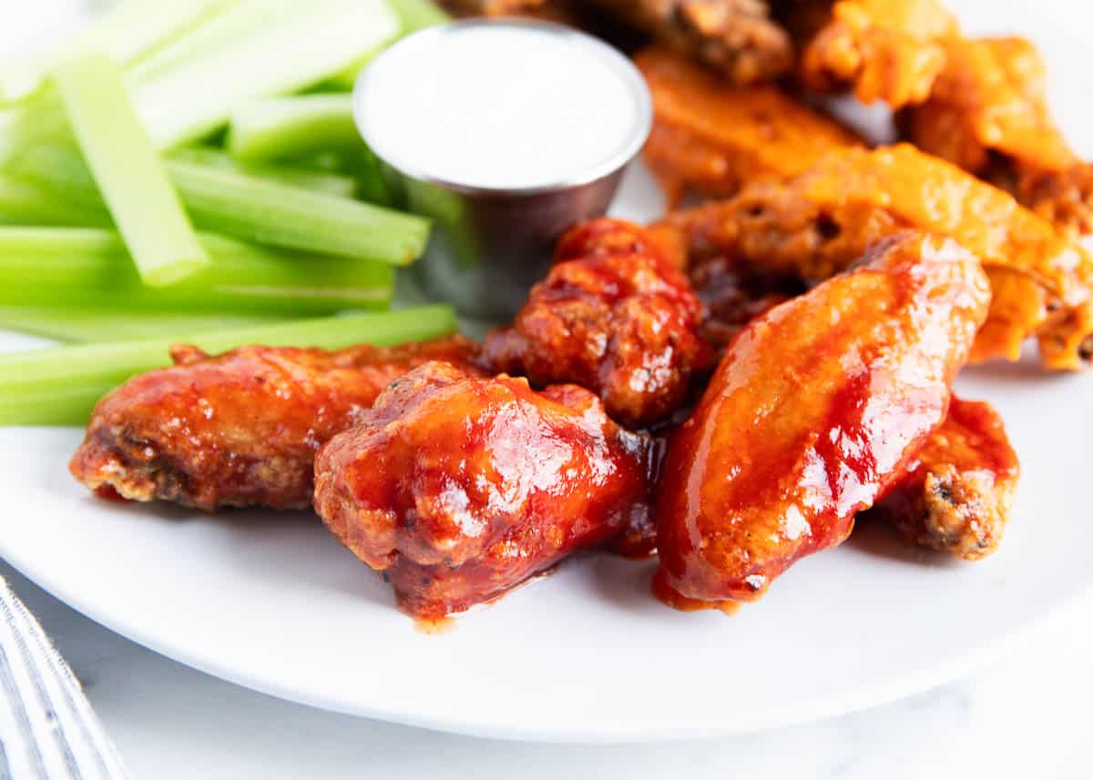 Chicken wings on a plate with celery with ranch.