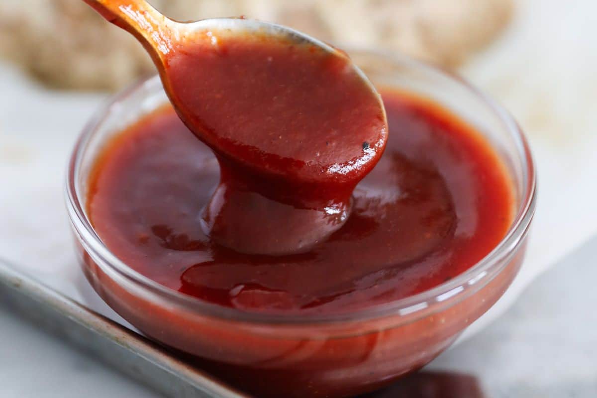 Meatloaf sauce being stirred in a small bowl, ready to spread over muffin tin meatloaf.