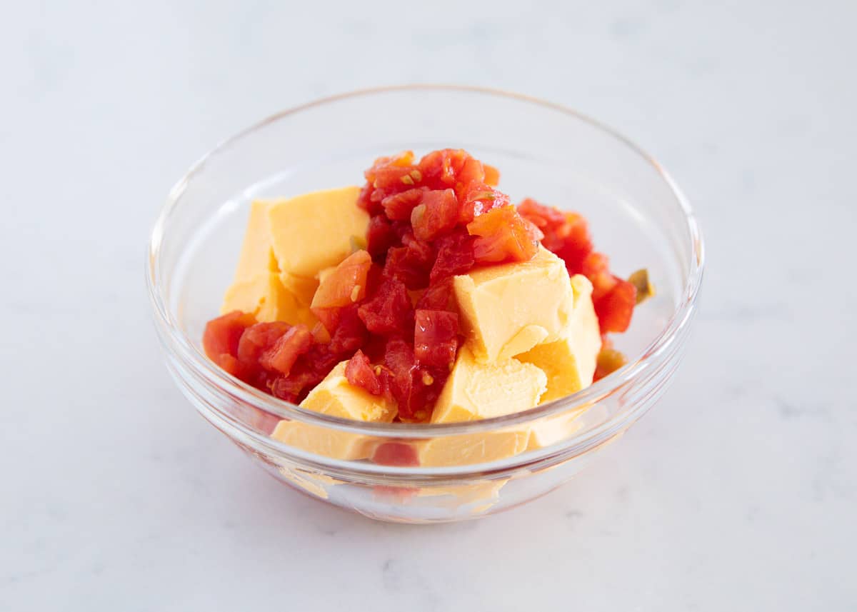 Showing how to make queso with velveeta in a glass bowl.