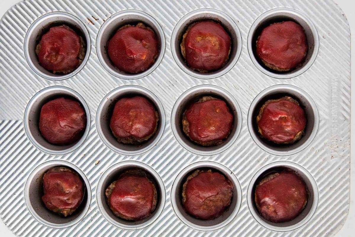 Mini meatloaf muffins baked in a muffin tin and topped with classic meatloaf sauce.