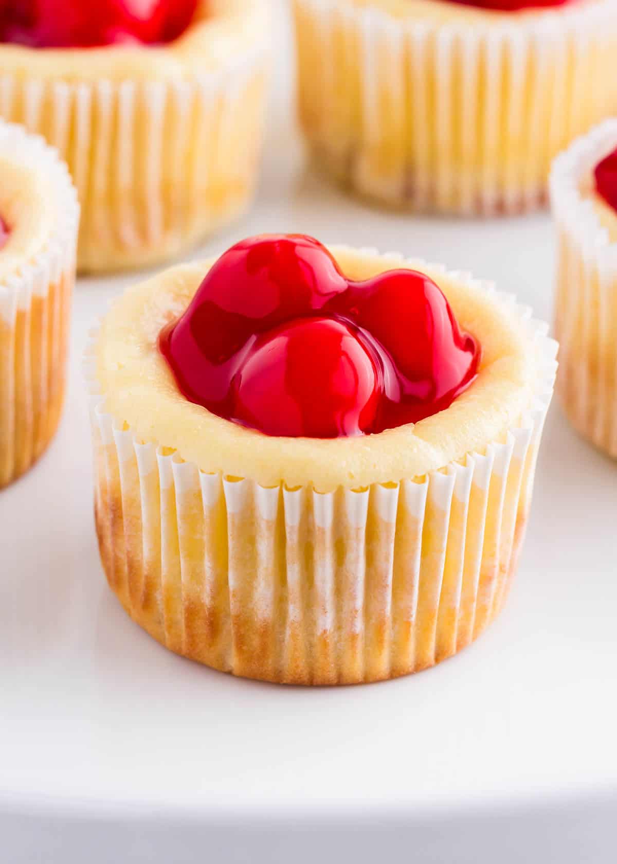 Mini cheesecakes with cherries on top. 