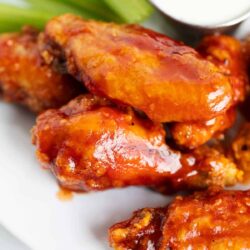 Chicken wings on a plate with celery with ranch.