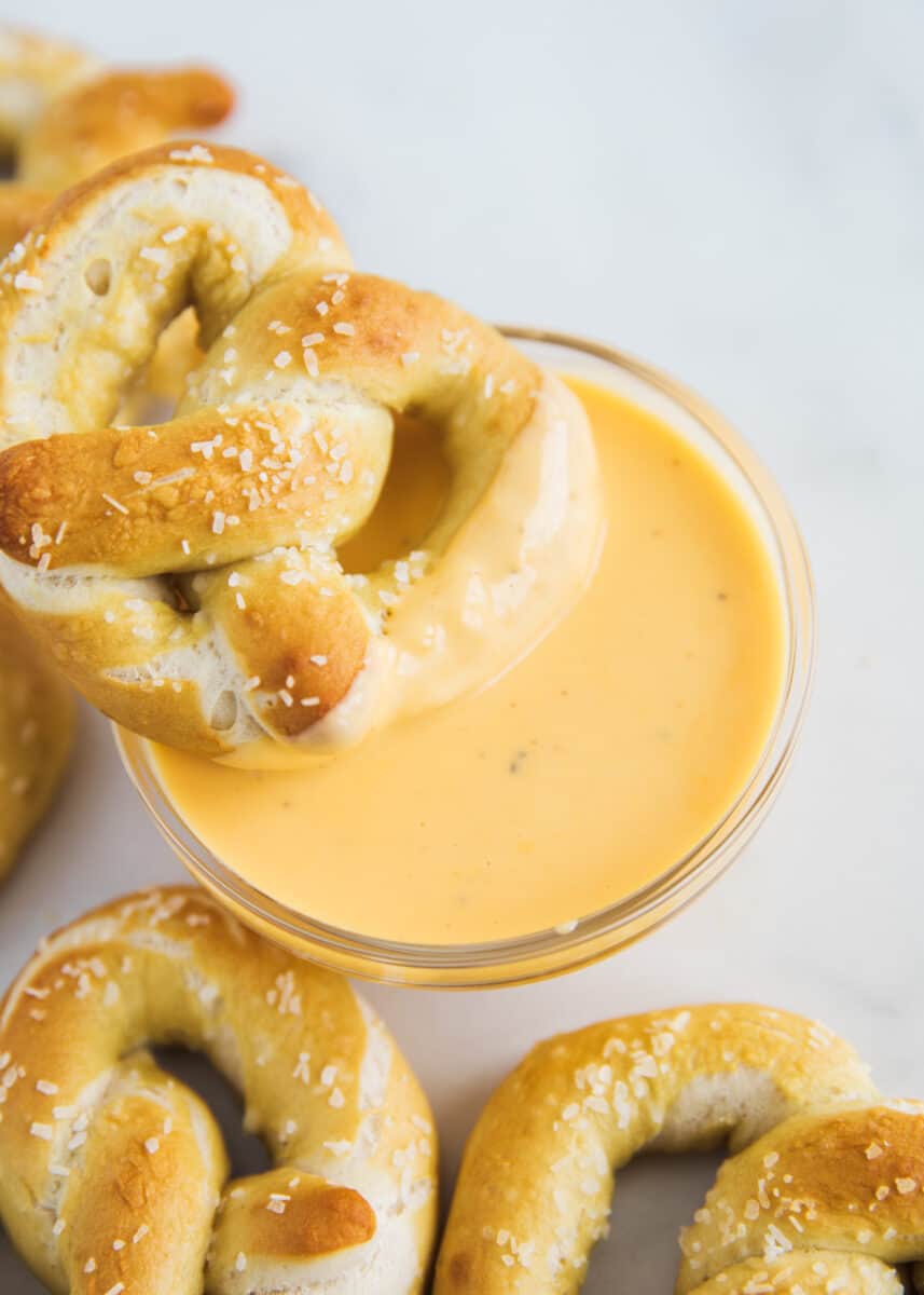 Pretzel dipped in cheese dip.
