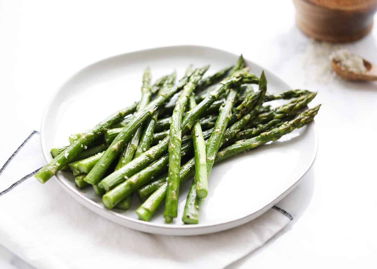 Roasted asparagus on a white plate. 