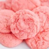 Close up of soft strawberry cake mix cookies on a white plate.