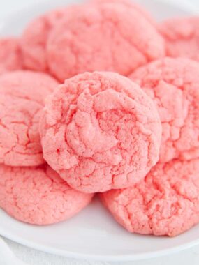 Close up of soft strawberry cake mix cookies on a white plate.