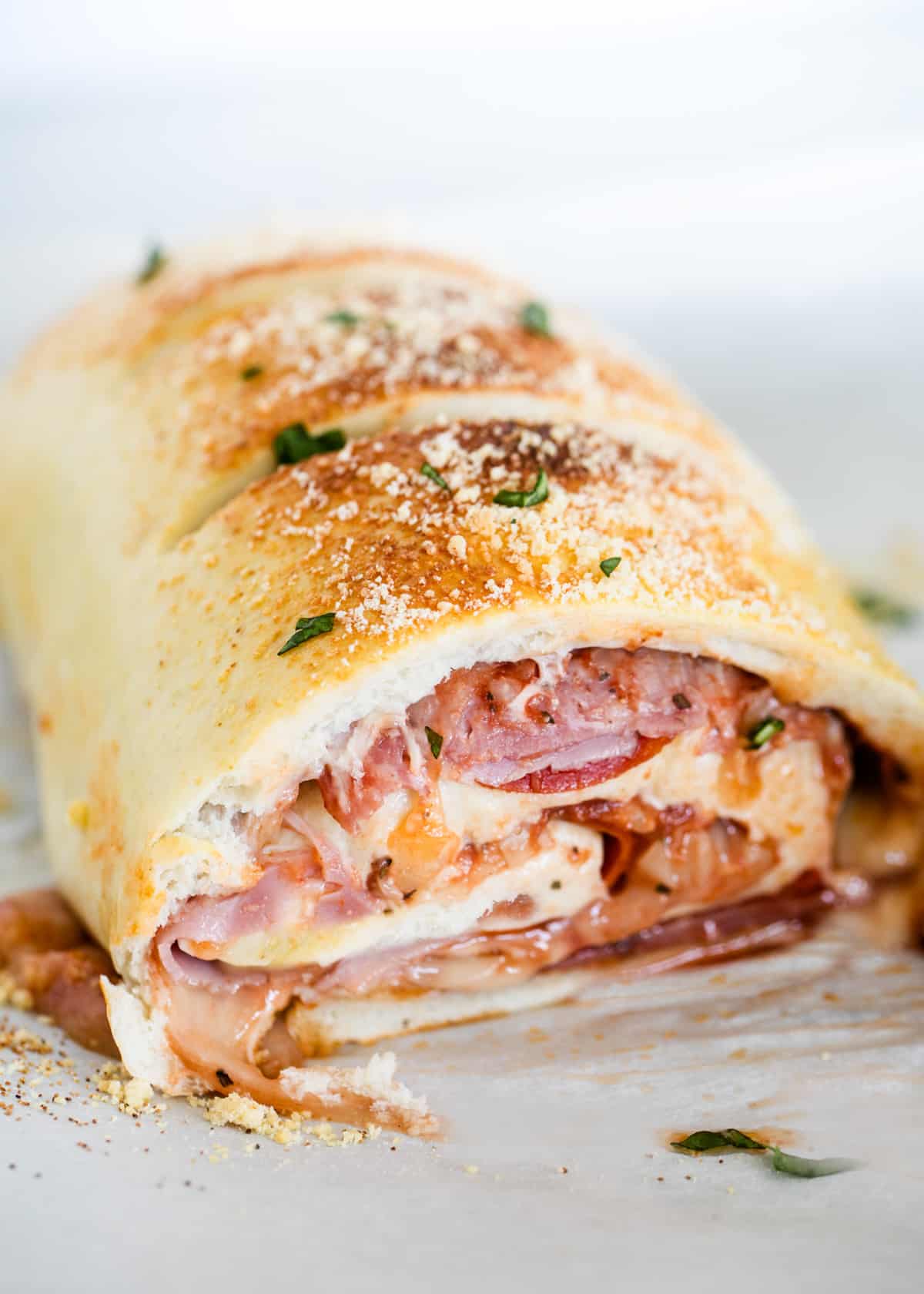 Stromboli cut in half on a baking sheet. 