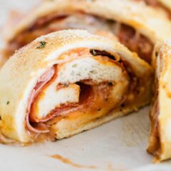 Sliced homemade stromboli filled with gooey cheese and savory meats.