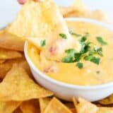 Dipping a chip into velveeta queso.