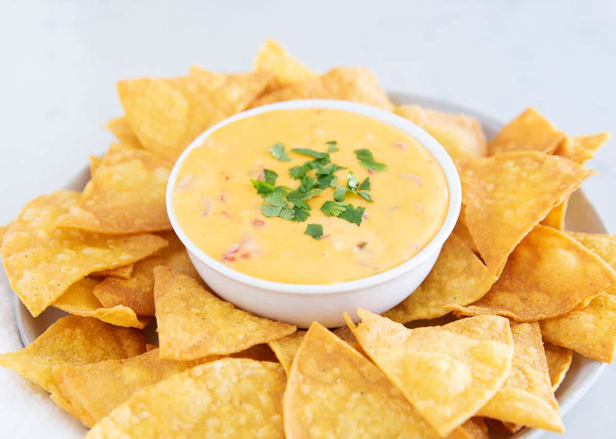 Velveeta queso in a white bowl with tortilla chips.