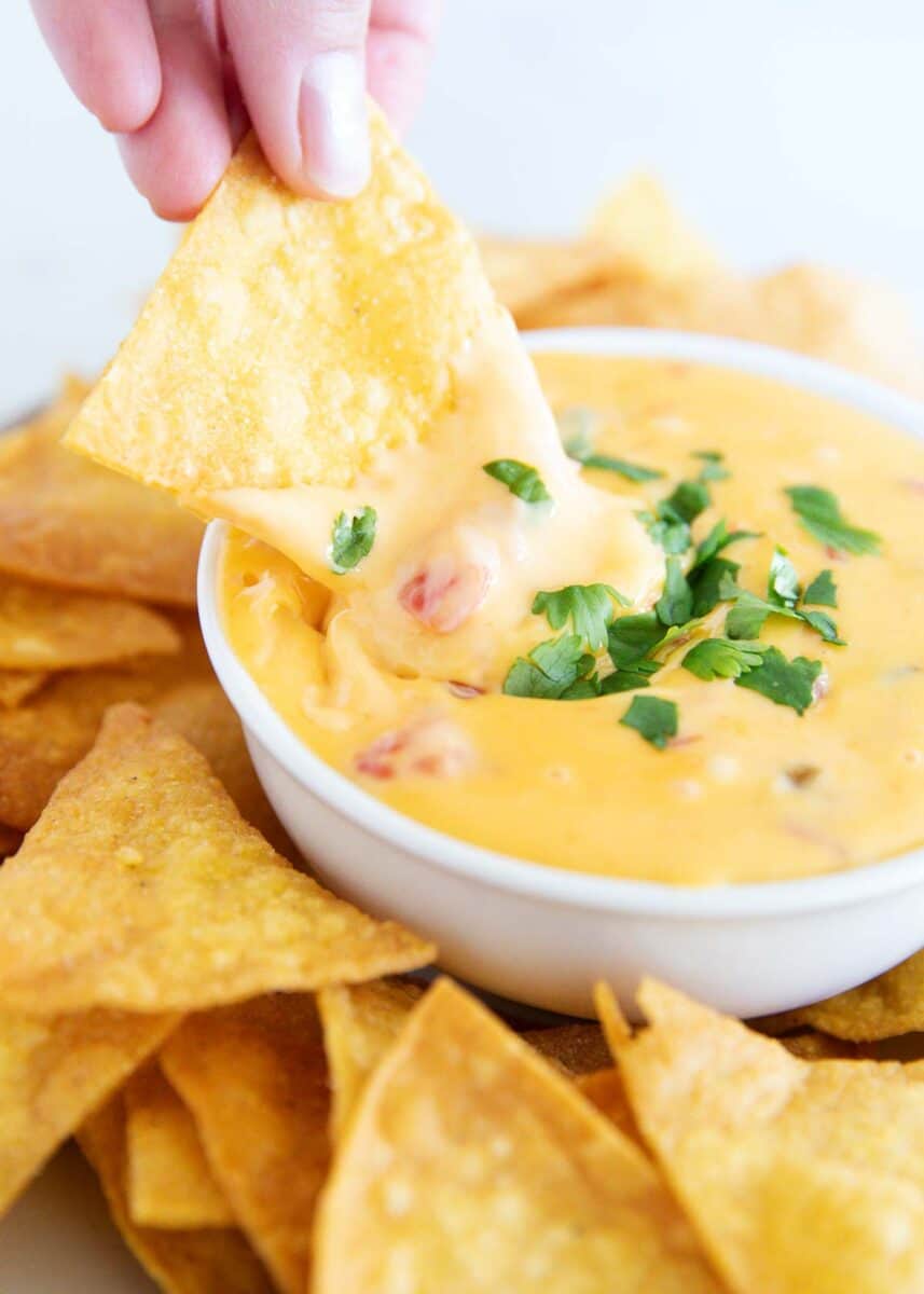 Dipping a chip into velveeta queso.