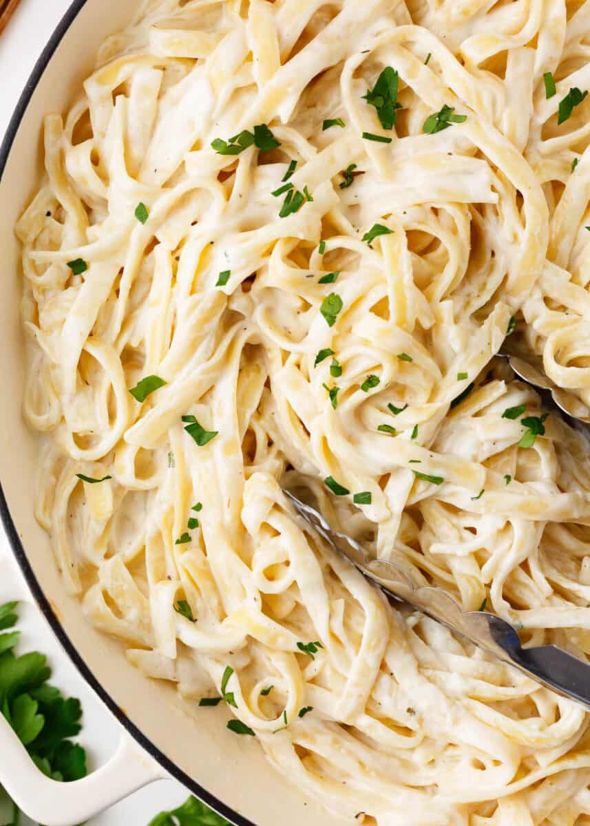 Homemade alfredo in a white pot.