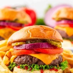 Baked hamburgers on a plate with toppings.