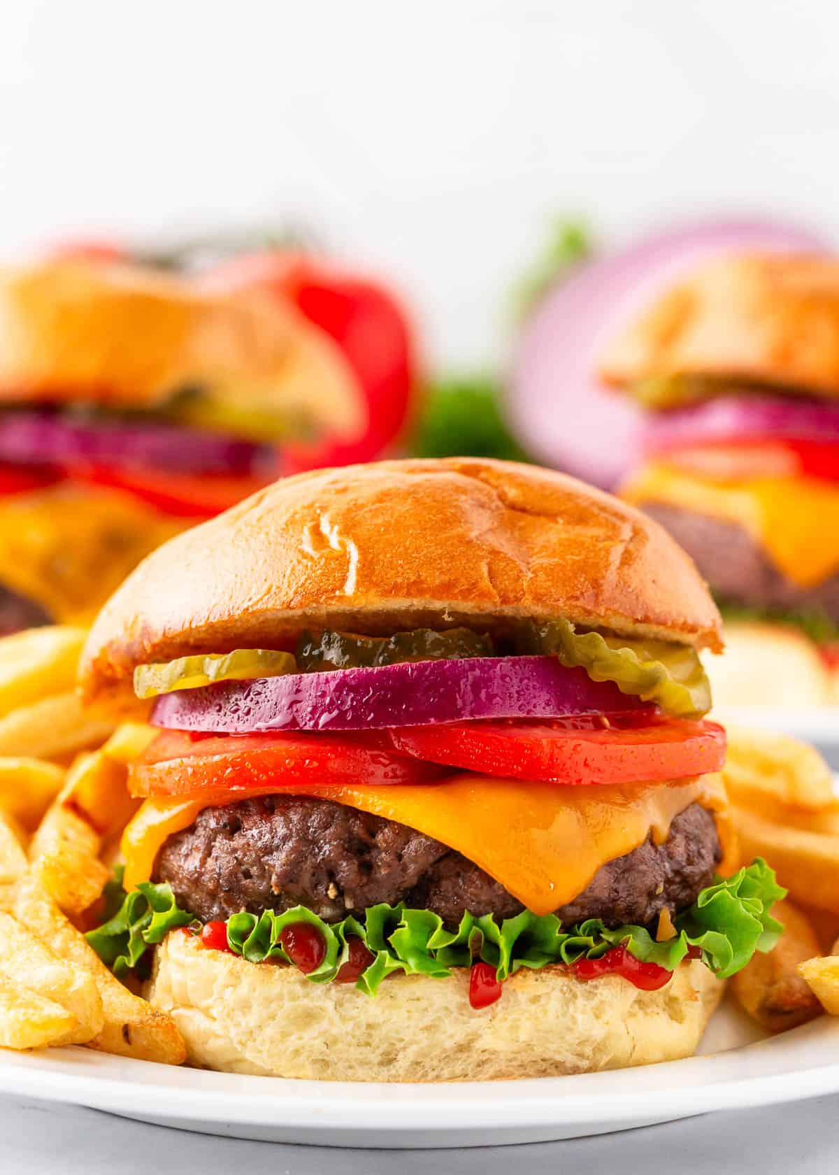 Baked hamburgers on a plate with toppings.