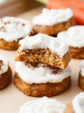 Stacked carrot cake cookies with cream cheese frosting.