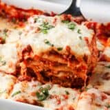 Slice of lasagna in baking dish.