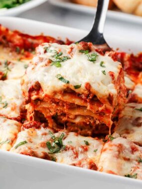 Slice of lasagna in baking dish.