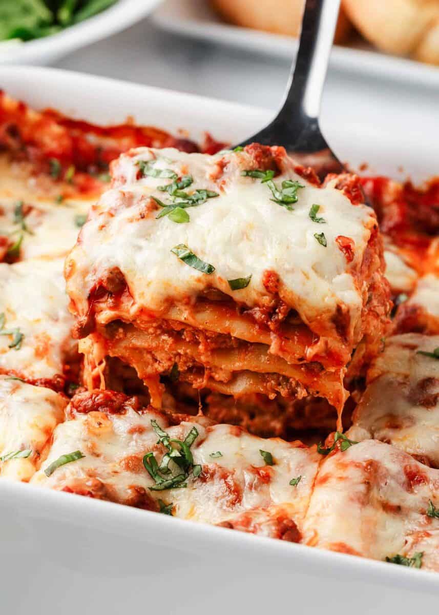 Slice of lasagna in baking dish.