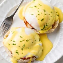 Eggs Benedict with Hollandaise Sauce on a white plate.