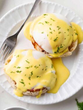 Classic eggs benedict topped with smooth hollandaise sauce on toasted English muffins.