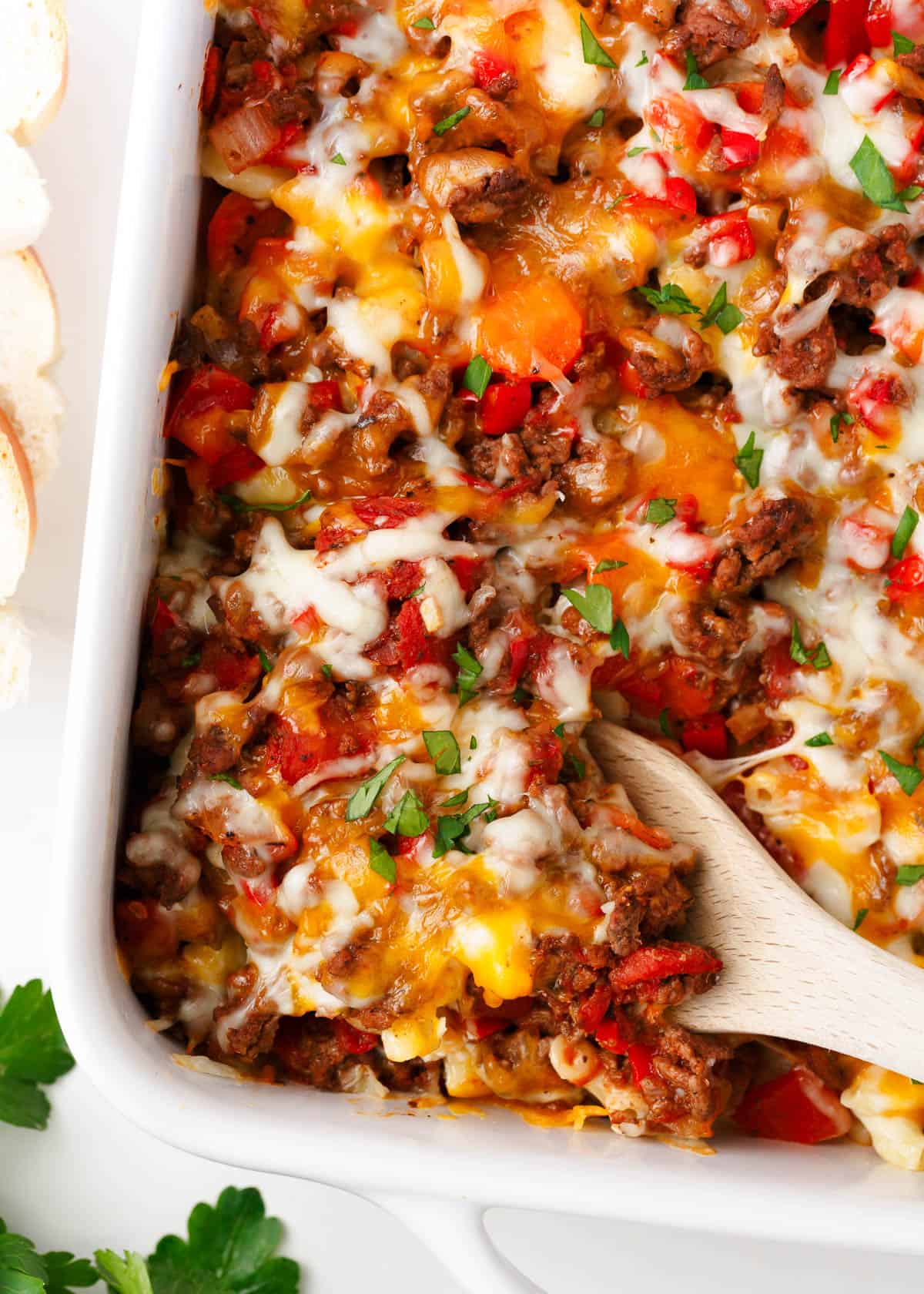 Hamburger casserole in a white baking dish with spoon.