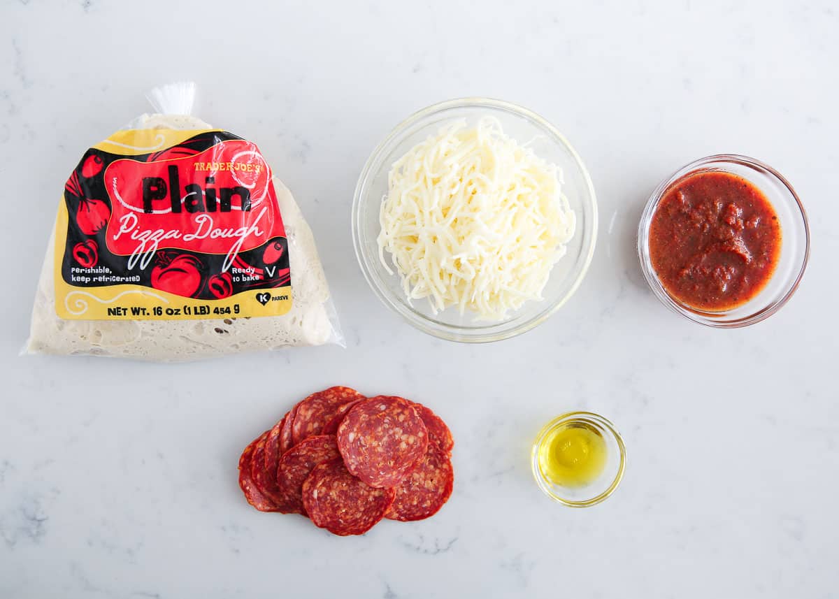 Heart shaped pizza ingredients on counter.