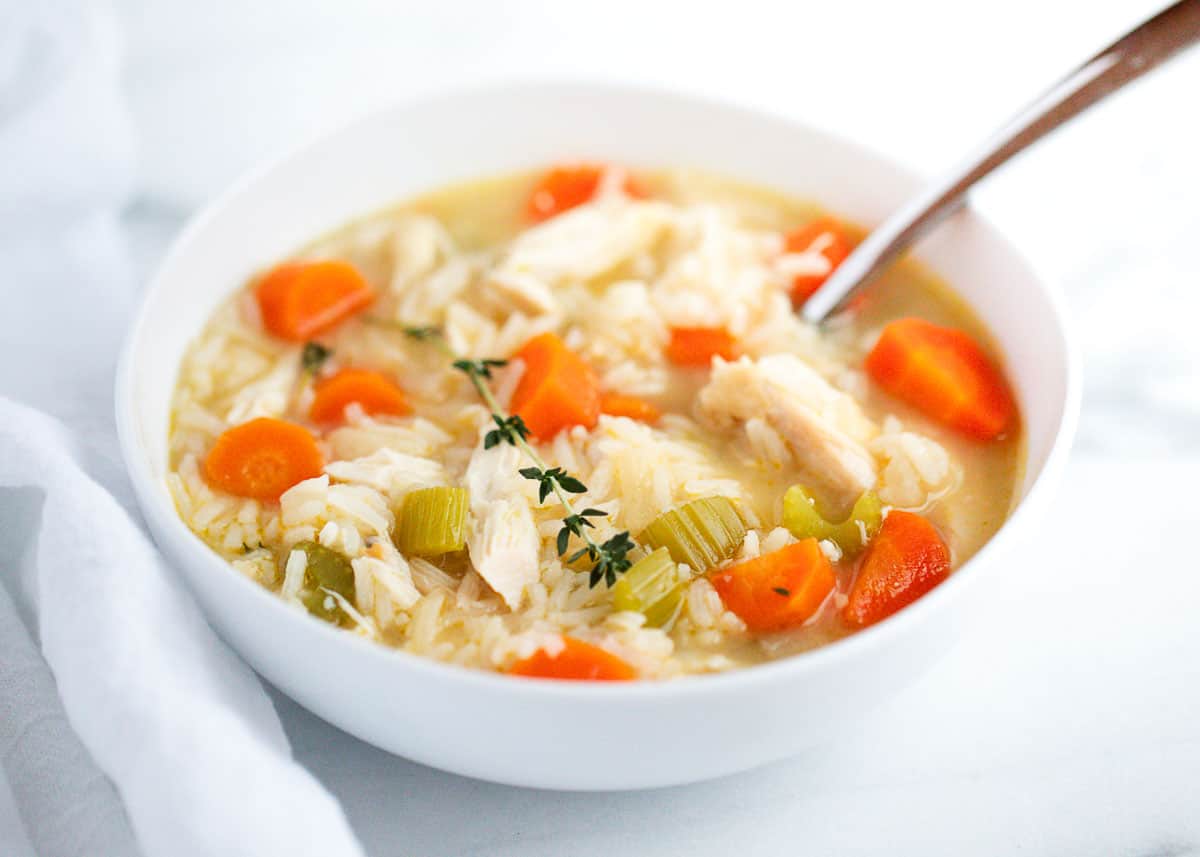 Chicken rice soup in a white bowl.