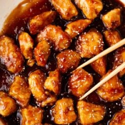 Honey sesame chicken cooking in a pot.