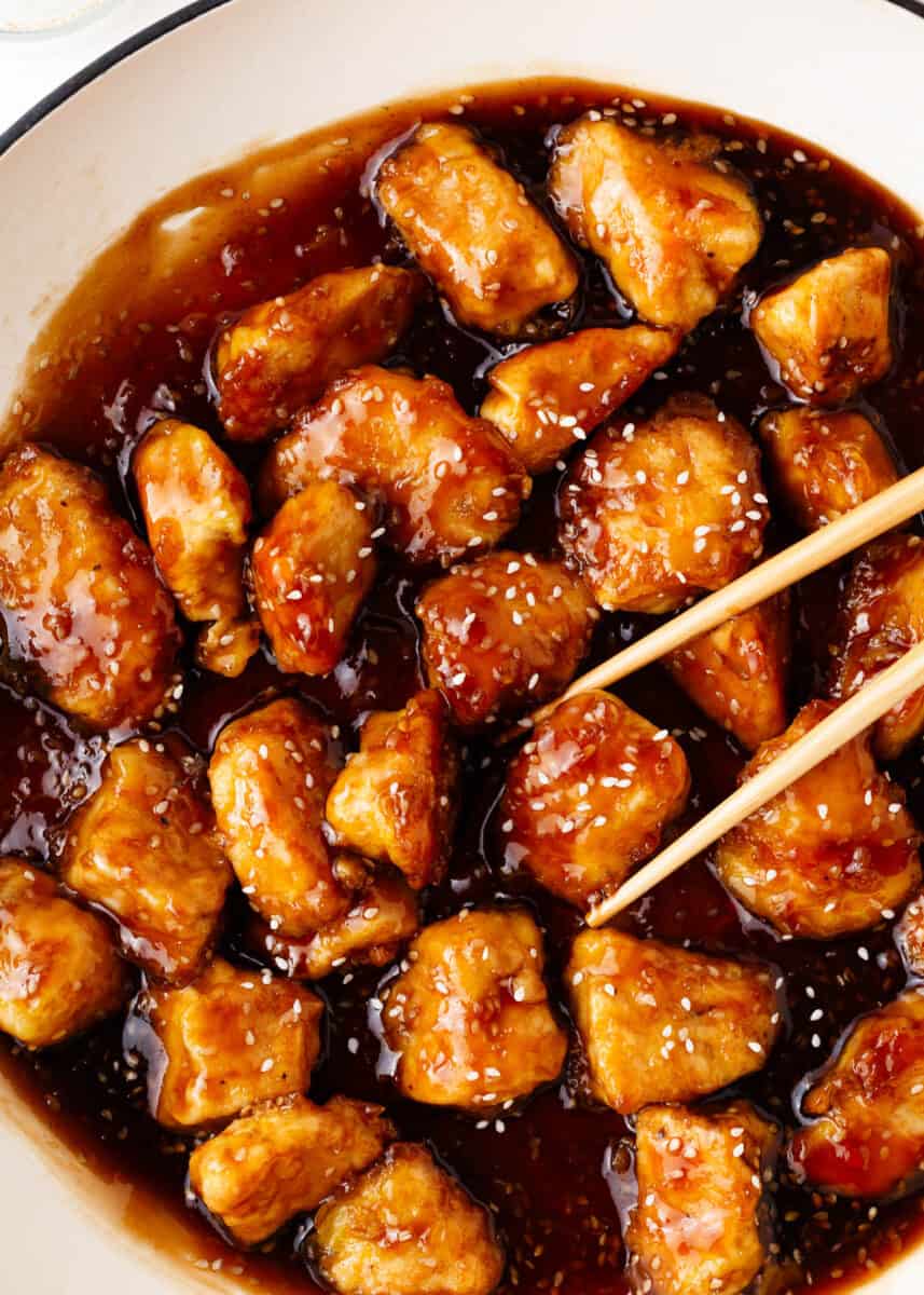 Honey sesame chicken cooking in a pot. 