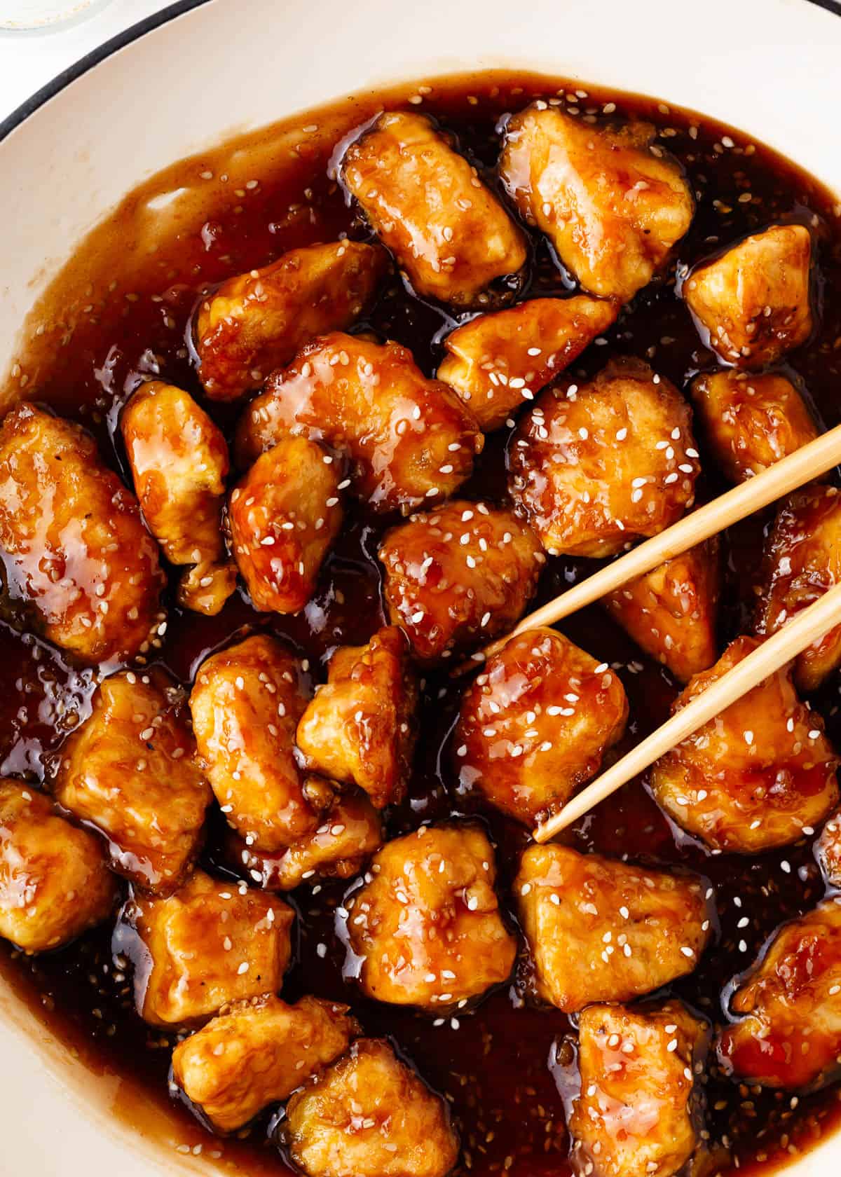 Honey sesame chicken cooking in a pot.