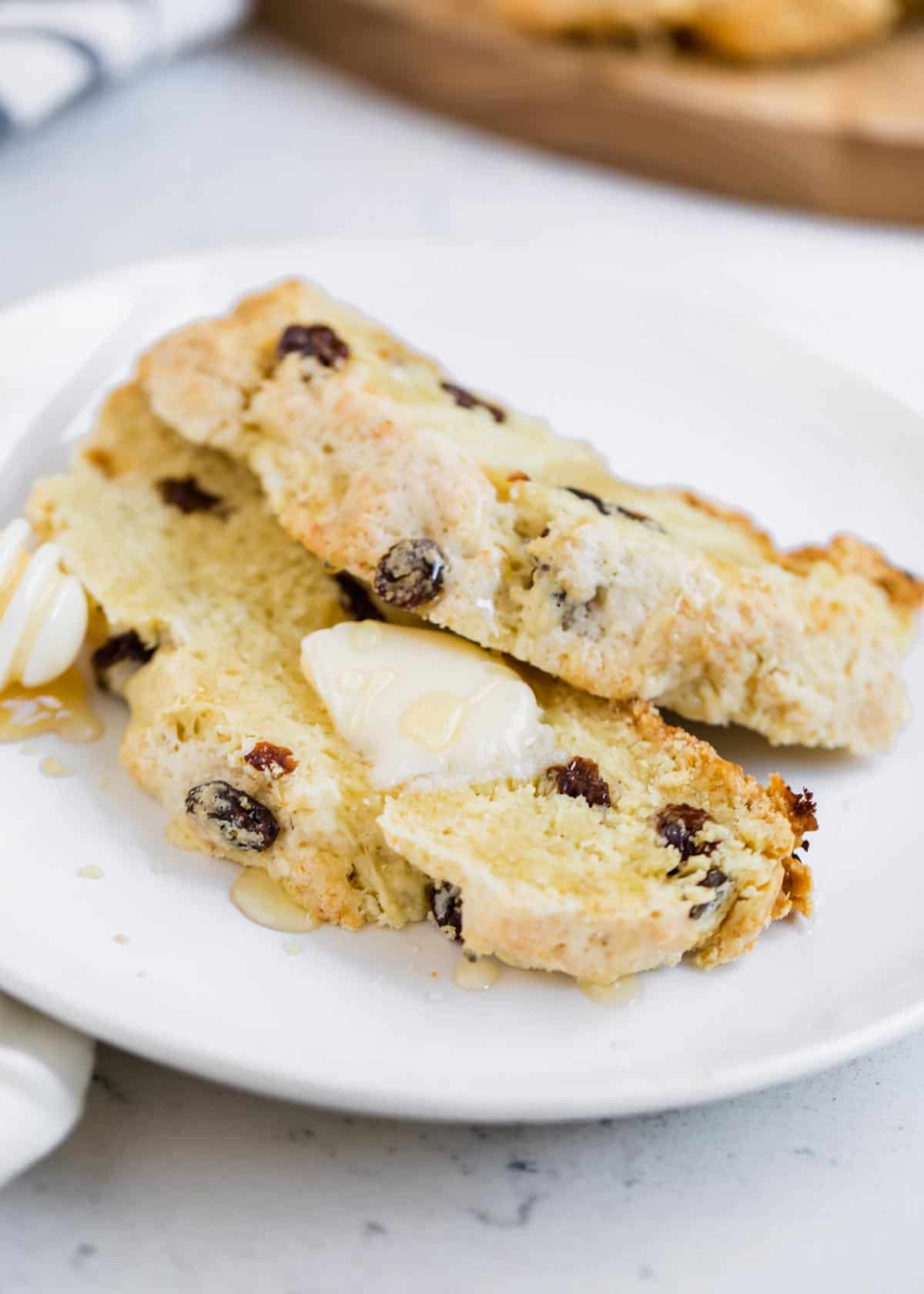 Two slices of Irish soda bread on a white plate. 