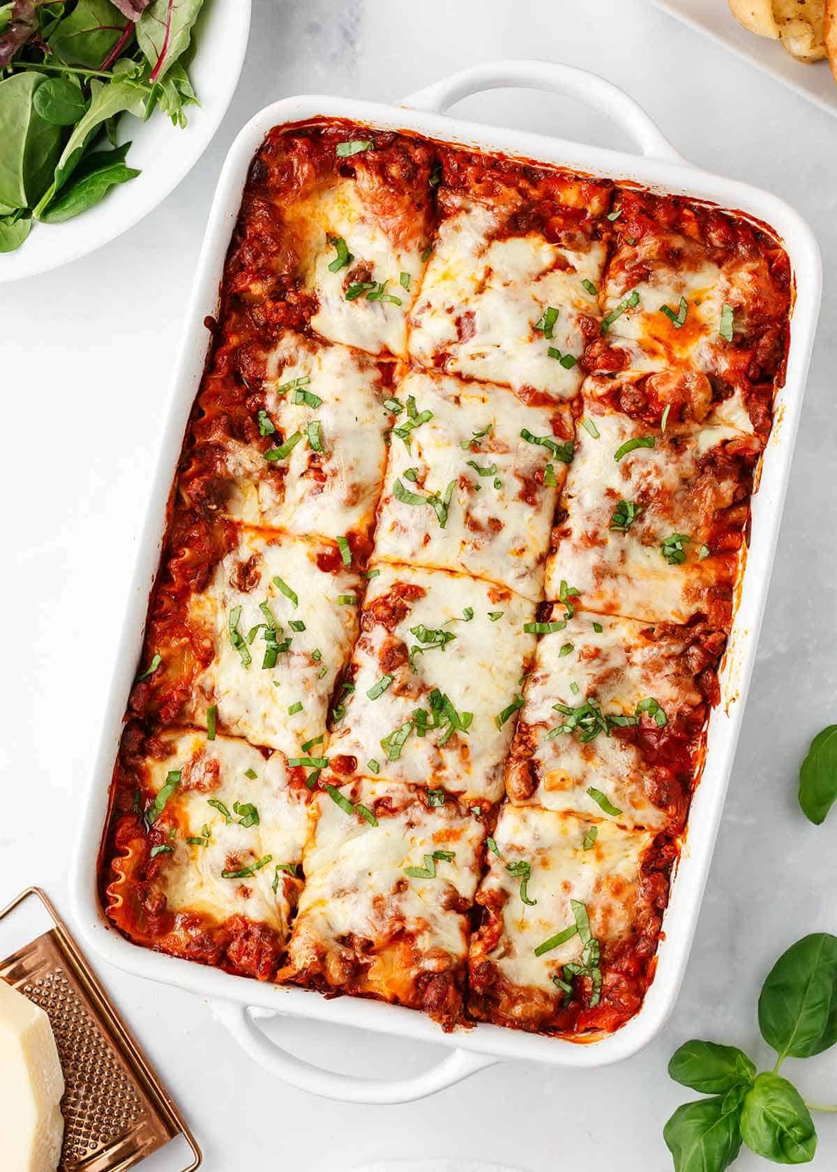 Lasagna cooked in a white casserole dish.