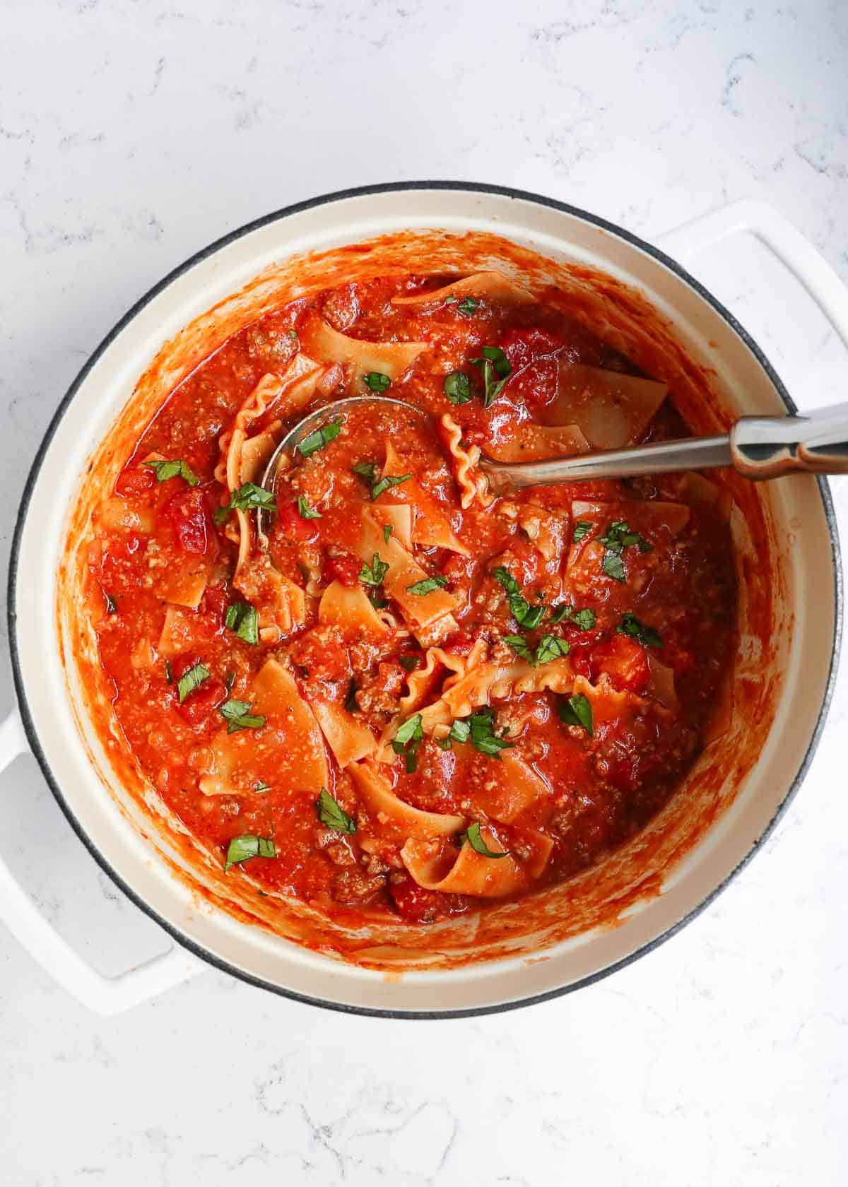 Lasagna soup in a white pot.
