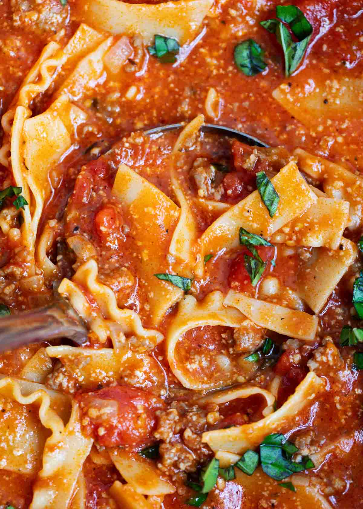 Ladle full of lasagna soup in a pot.