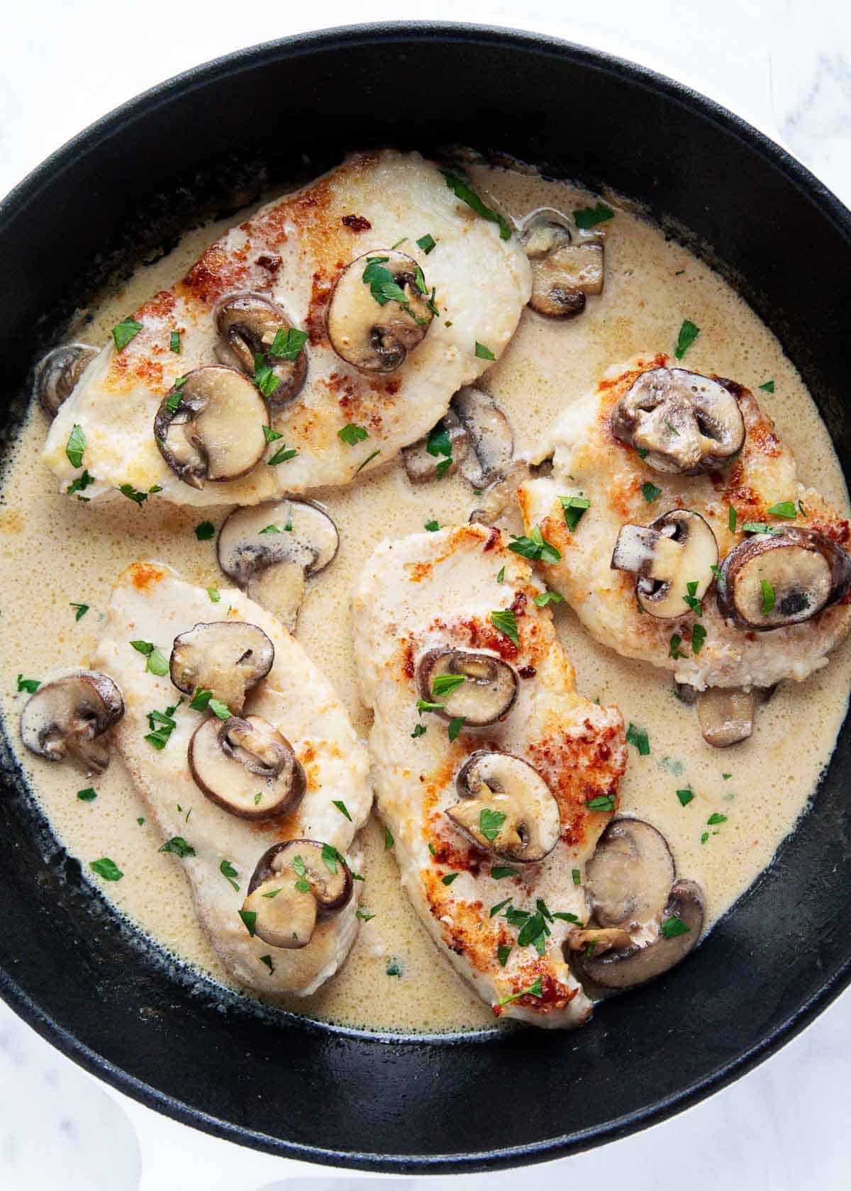 Chicken marsala cooked in an iron skillet.