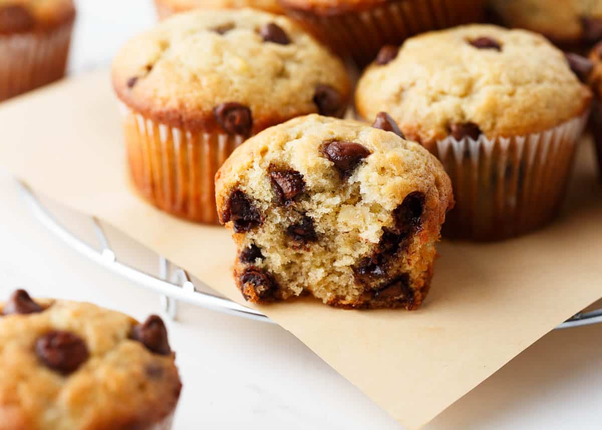 Chocolate chip banana muffins on brown parchment paper.