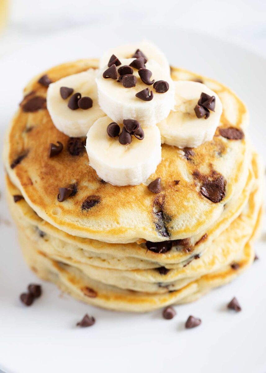 Stack of chocolate chip pancakes with chocolate chips and bananas.