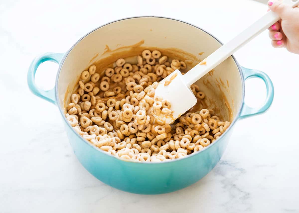 Cereal bars being stirred in a large pot. 