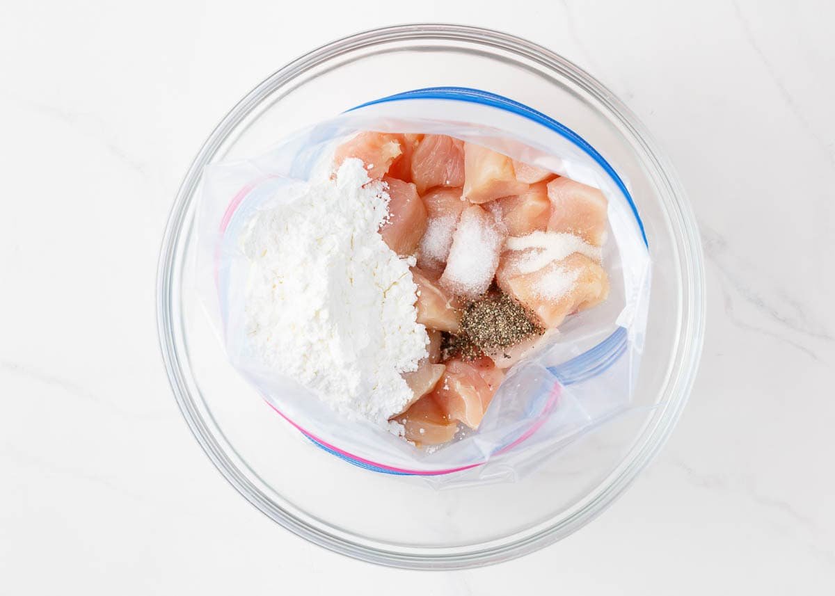 Coating chicken pieces in flour.