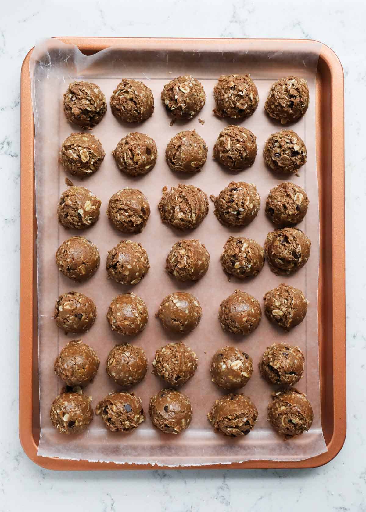 Protein balls lined up on a cookie sheet.