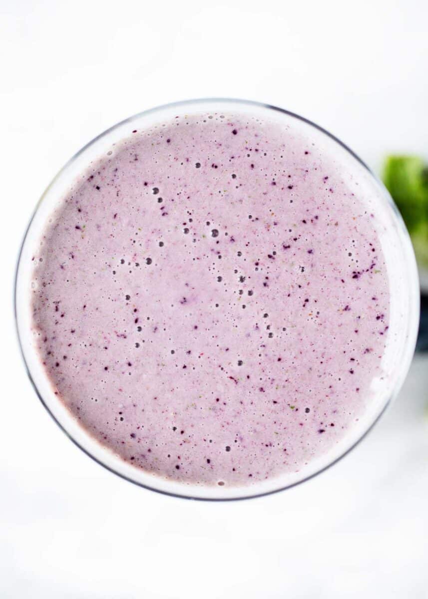 Kale berry smoothie in a glass cup.