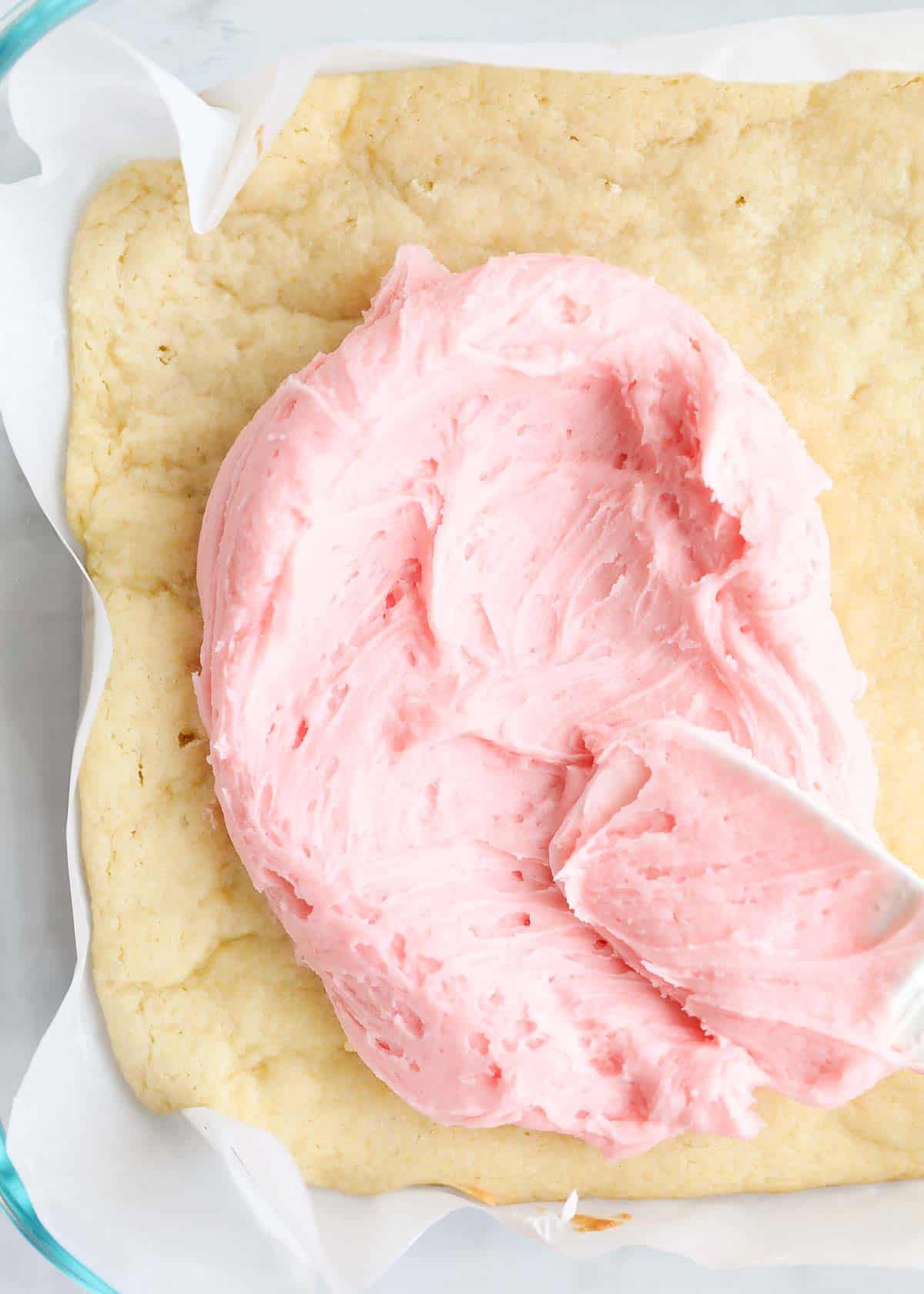 Sugar cookie bars with frosting on it. 