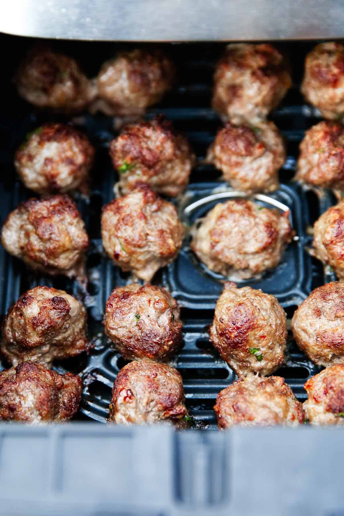 Air fryer meatballs in air fryer basket.