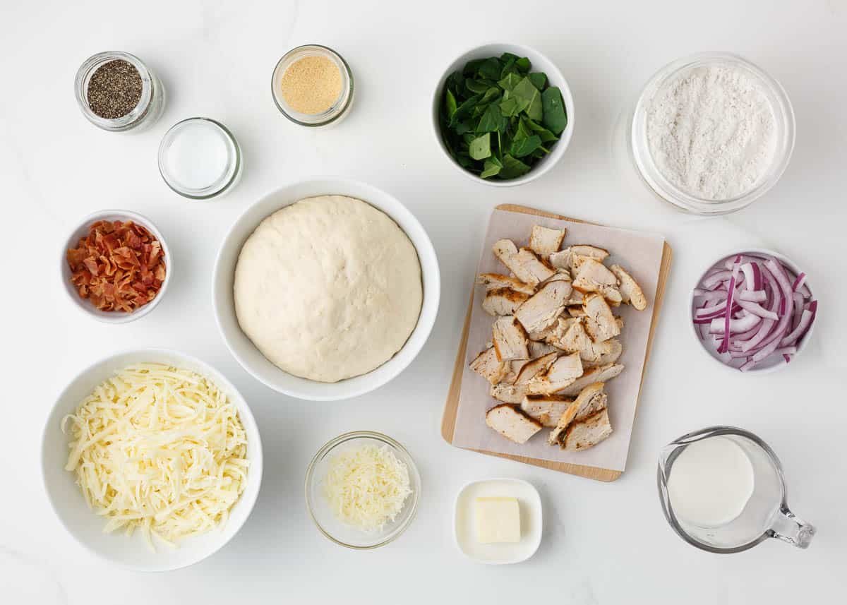 Alfredo pizza ingredients on the counter.