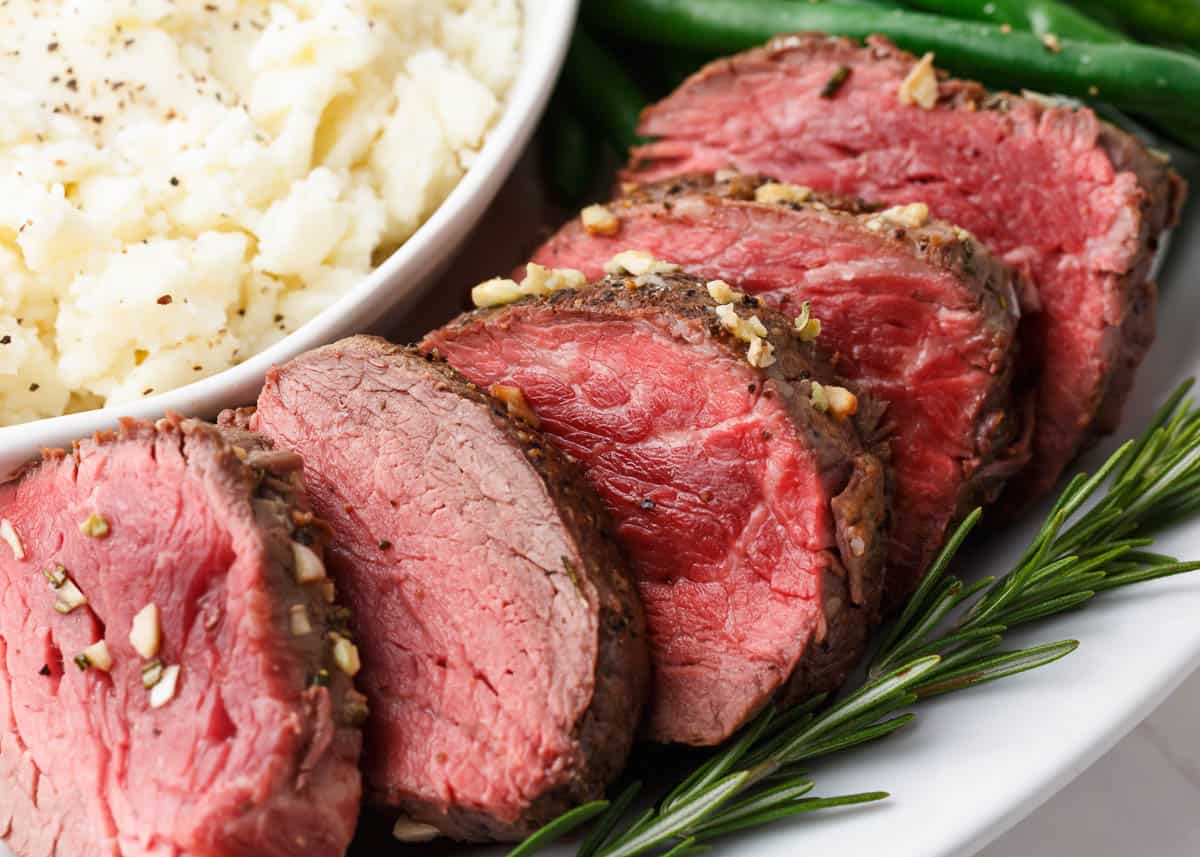 Close up of sliced beef tenderloin recipe on plate showing tender, juicy results.