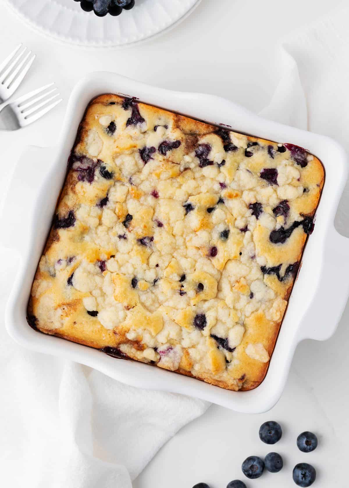 Blueberry coffee cake in a white baking dish.