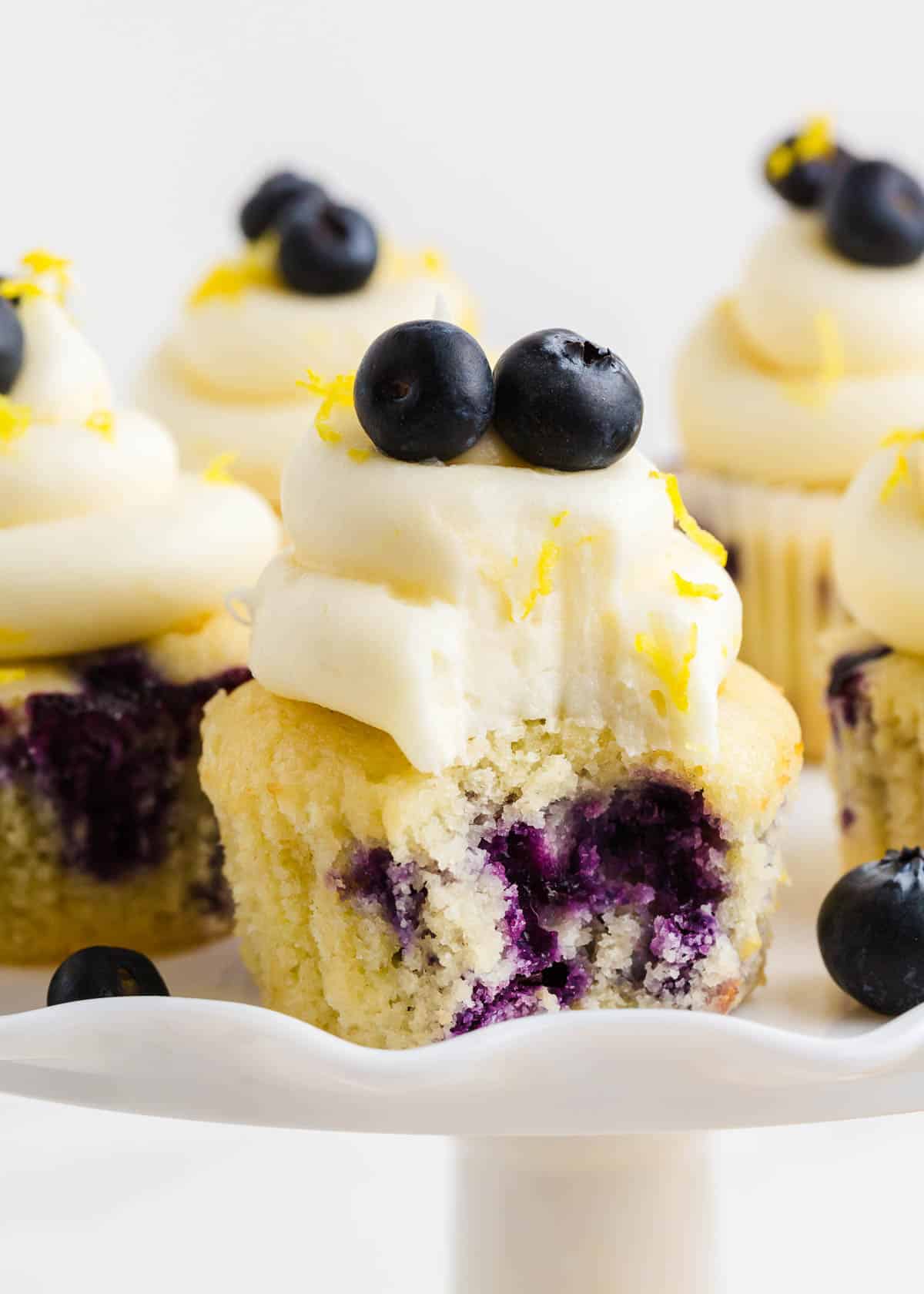 A bite taken out of lemon blueberry cupcakes. 