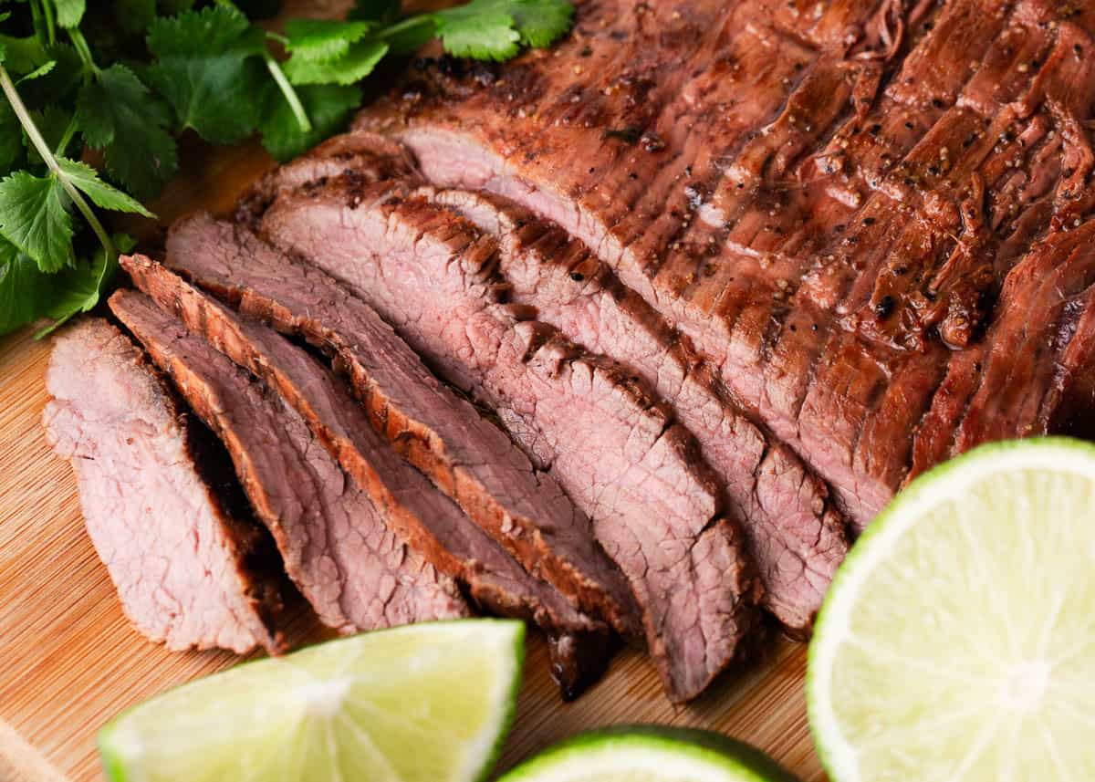 Sliced carne asada on a cutting board.