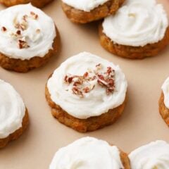 Soft carrot cake cookies with cream cheese frosting on the counter.